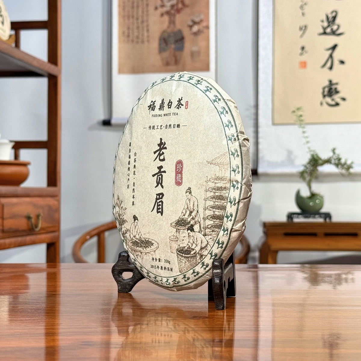 2015 Fuding Gong Mei White Tea Cake (Tribute Eyebrow) displayed in a traditional Chinese tea house