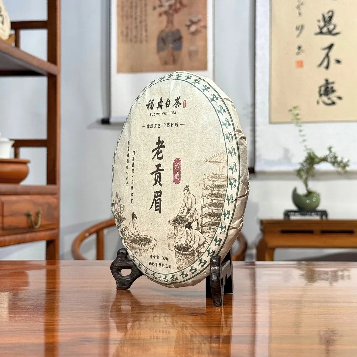 2015 Fuding Gong Mei White Tea Cake (Tribute Eyebrow) displayed in a traditional Chinese tea house