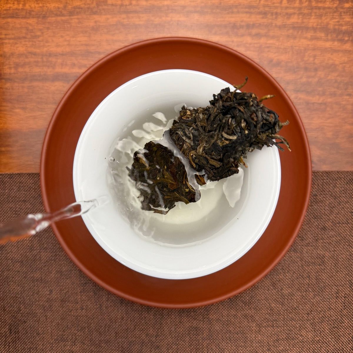 2016 He Kai Raw Pu-erh Tea Cake brewed in a traditional Chinese tea room, revealing aged Pu-erh tea character