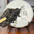 Close-up of the 2018 Bing Dao Raw Pu'er Tea Cake Sample showing broken leaves