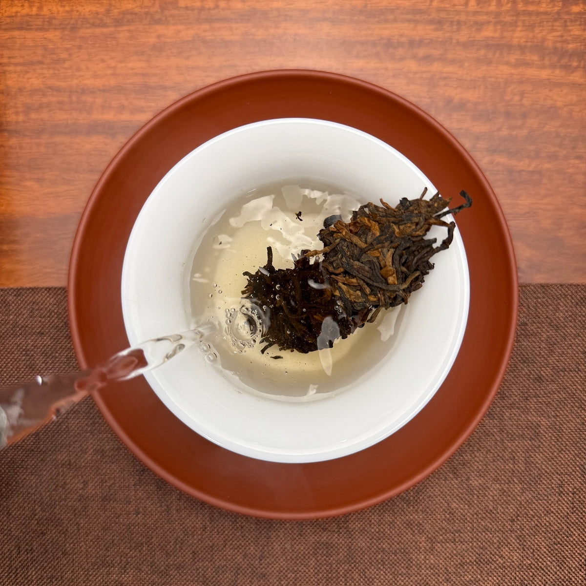 2019 Lao Ban Zhang Golden Tips Ripe Pu-erh Tea Cake being brewed in a traditional tea setting