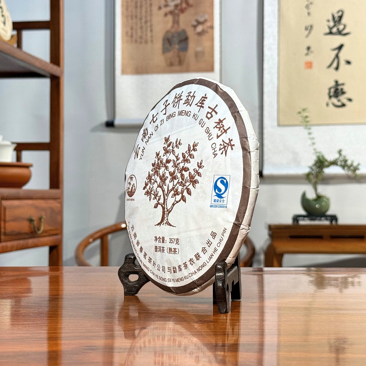 2019 Yunnan Qizi Bing Ripe Pu-erh Tea Cake side view displayed in a traditional Chinese tea house