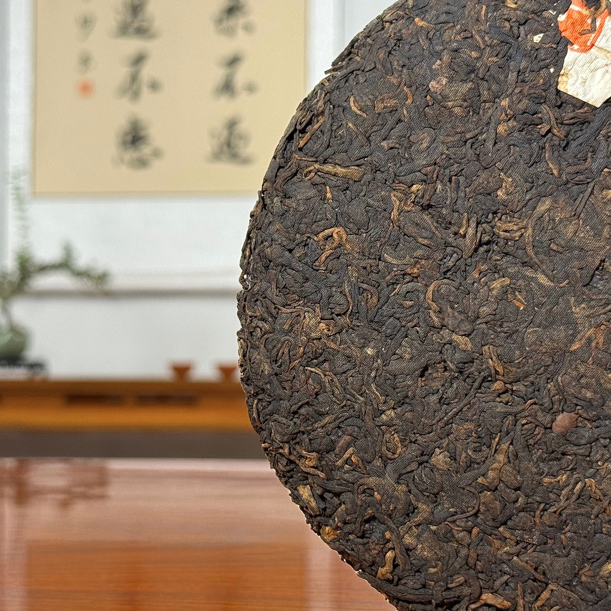 Close-up of 2020 Arbor Tree Ripe Pu-erh Tea Cake (Shou) showing the dark brown tea leaves and cake texture