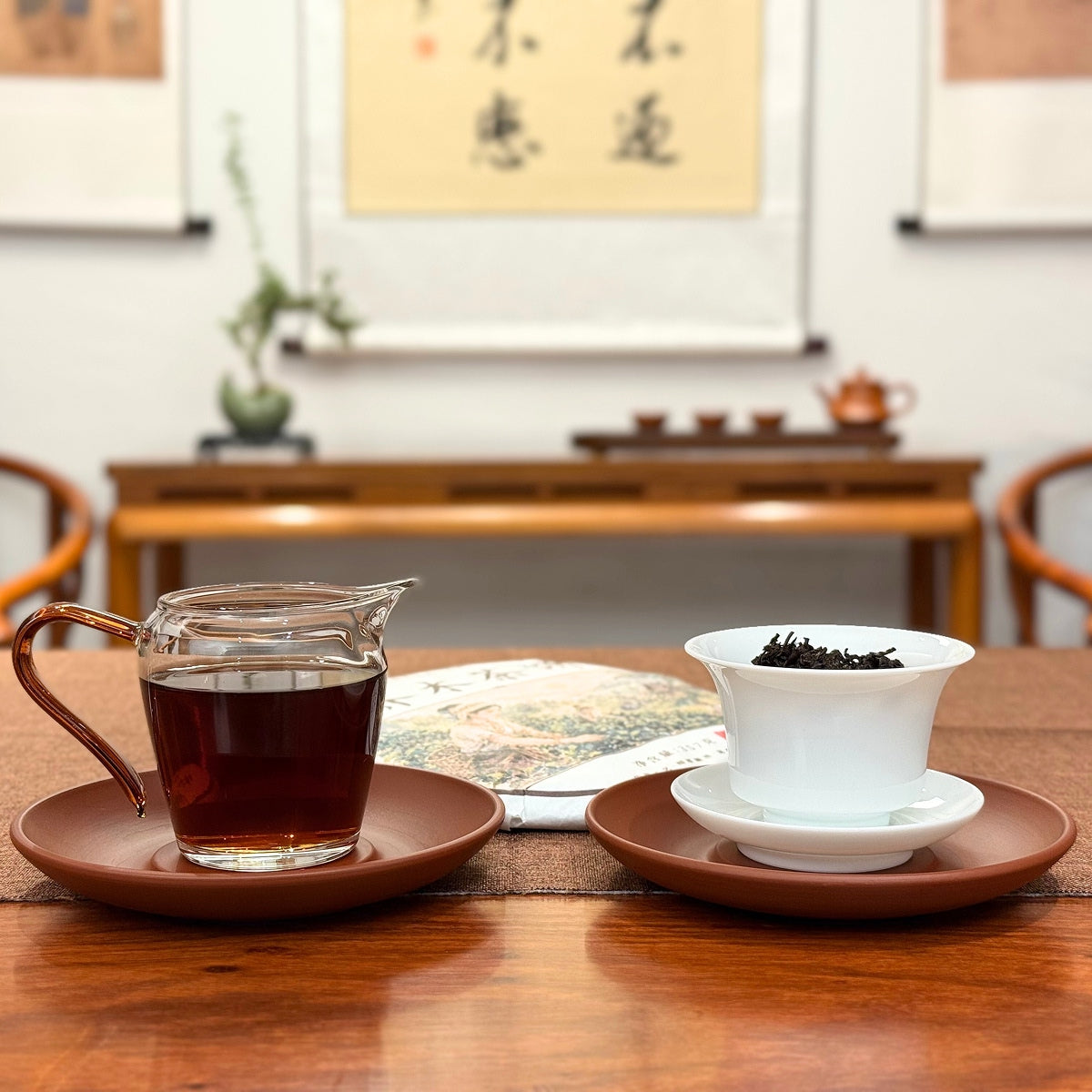2020 Arbor Tree Ripe Pu-erh Tea Cake (Shou) served with brewed tea on a traditional tea table