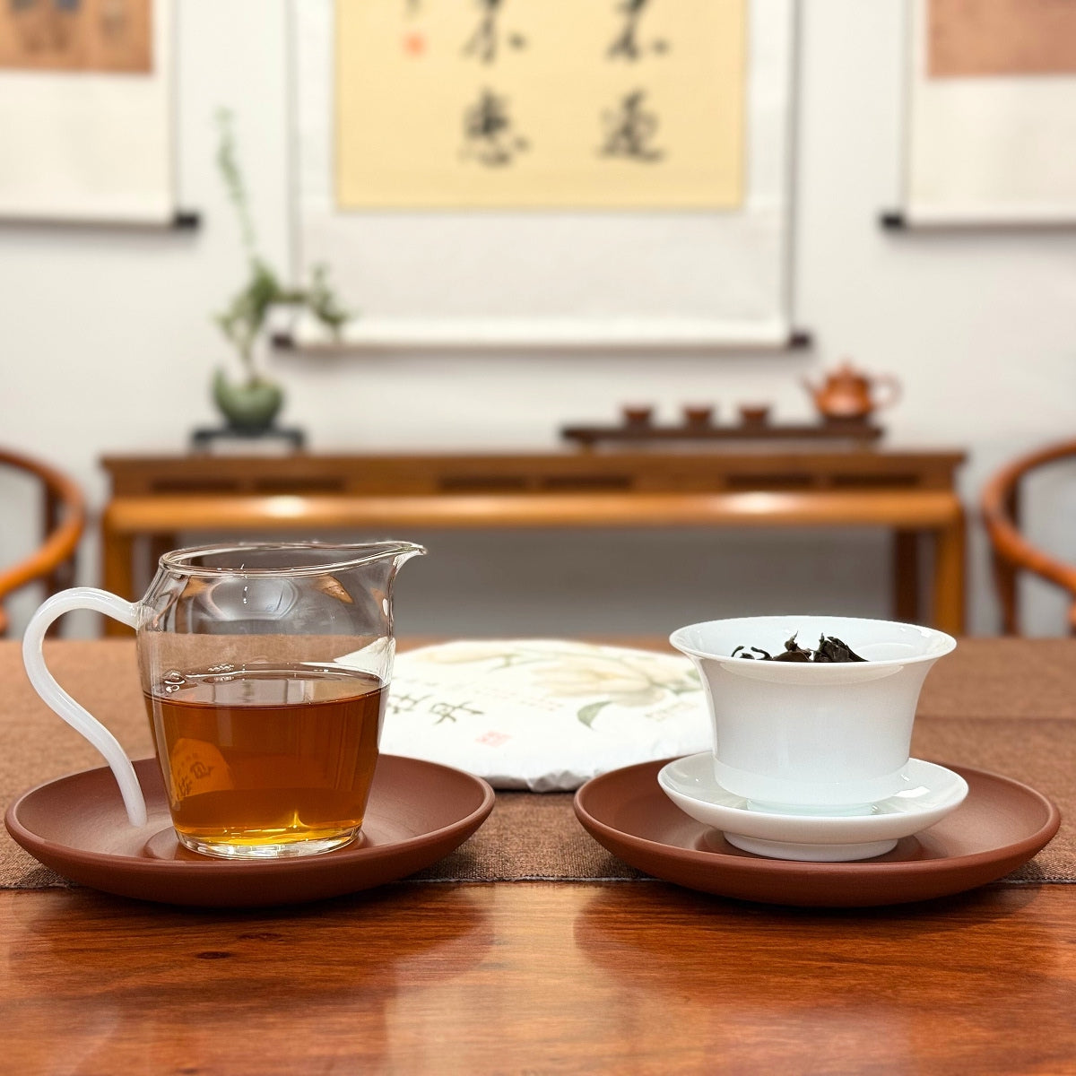 2021 Fuding Bai Mu Dan White Tea Cake (White Peony) with brewed white tea liquor on a tea table