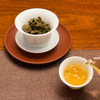 2022 Ban Pen Ancient Tree Raw Pu-erh Tea Cake with clear tea liquor displayed at Chinese Tea Group tea house