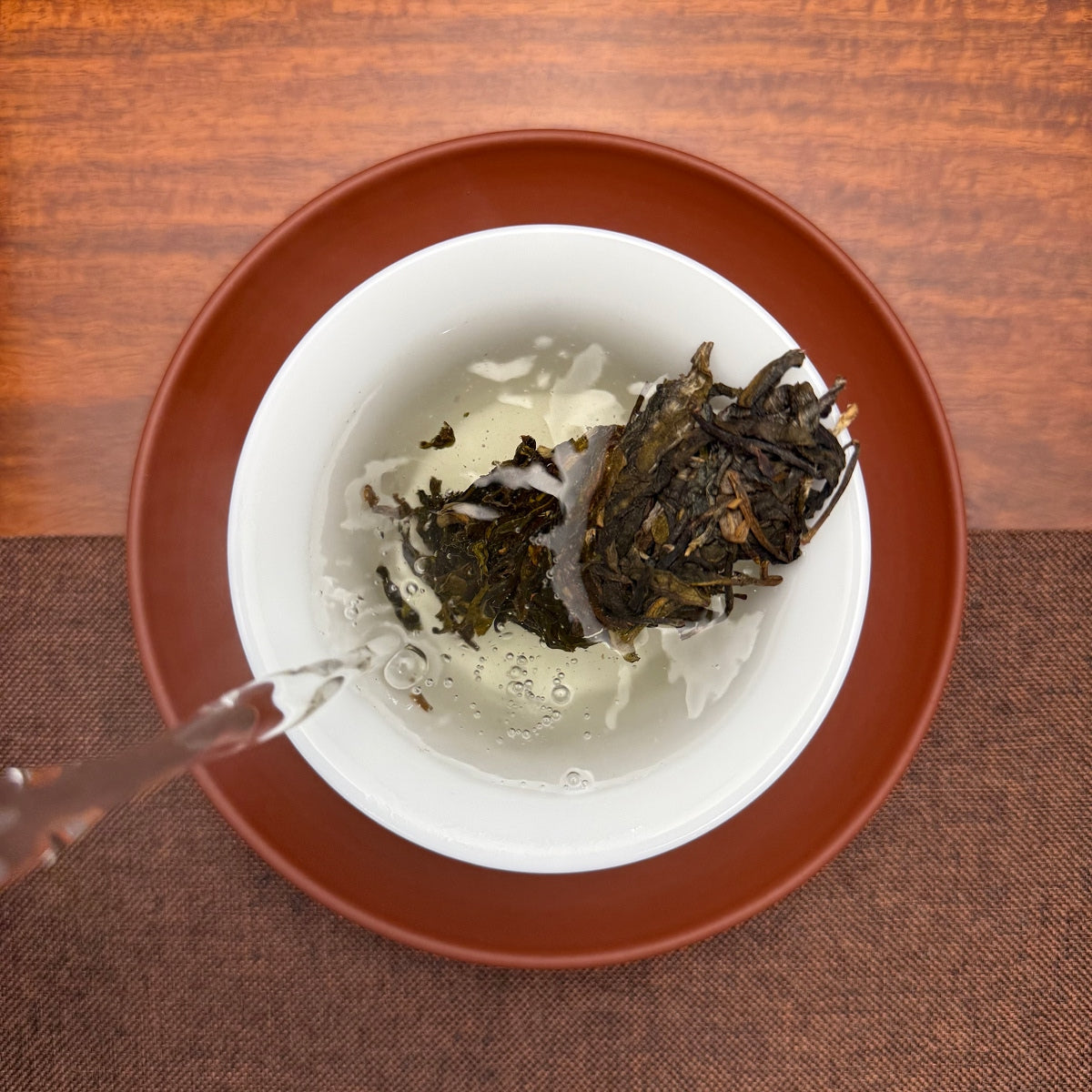 2023 Da Xue Shan Ancient Tree Raw Pu-erh Tea Cake being brewed with traditional Chinese tea preparation methods.
