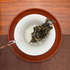 2024 Lin Cang Ancient Tree Raw Pu-erh Tea Cake being brewed in a traditional Chinese tea room.