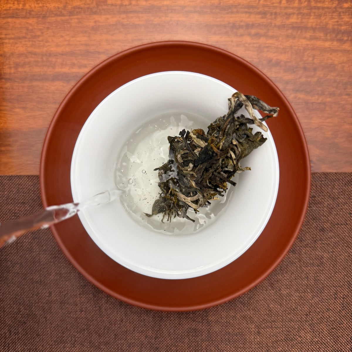 2024 Lin Cang Ancient Tree Raw Pu-erh Tea Cake being brewed in a traditional Chinese tea room.