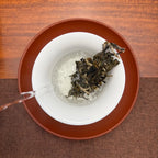 2024 Lin Cang Ancient Tree Raw Pu-erh Tea Cake being brewed in a traditional Chinese tea room.