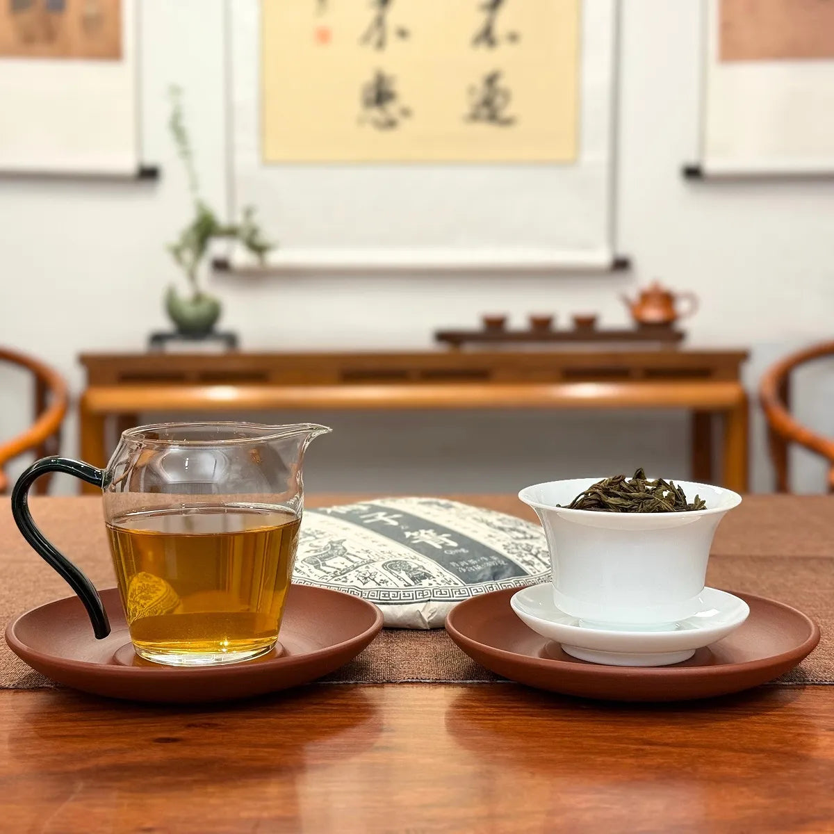 2024 Mei Zi Qing Raw Pu-erh Tea Cake displayed with brewed tea liquor
