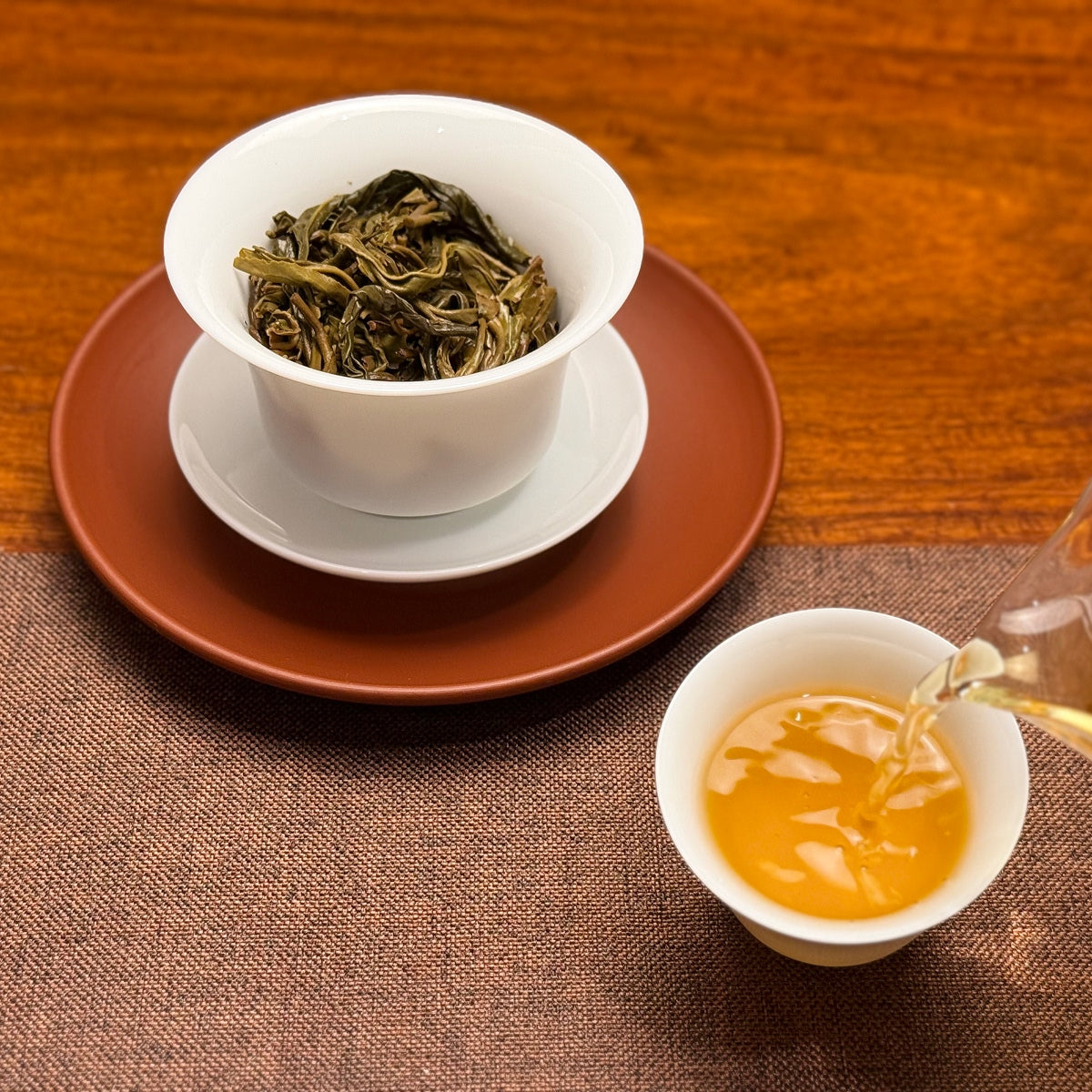2024 Xiao Hu Sai Raw Pu-erh Tea Cake with clear golden tea liquor after brewing