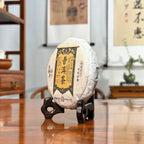 2025 Raw Pu-erh Tea Cake side view displayed in a traditional Chinese tea house