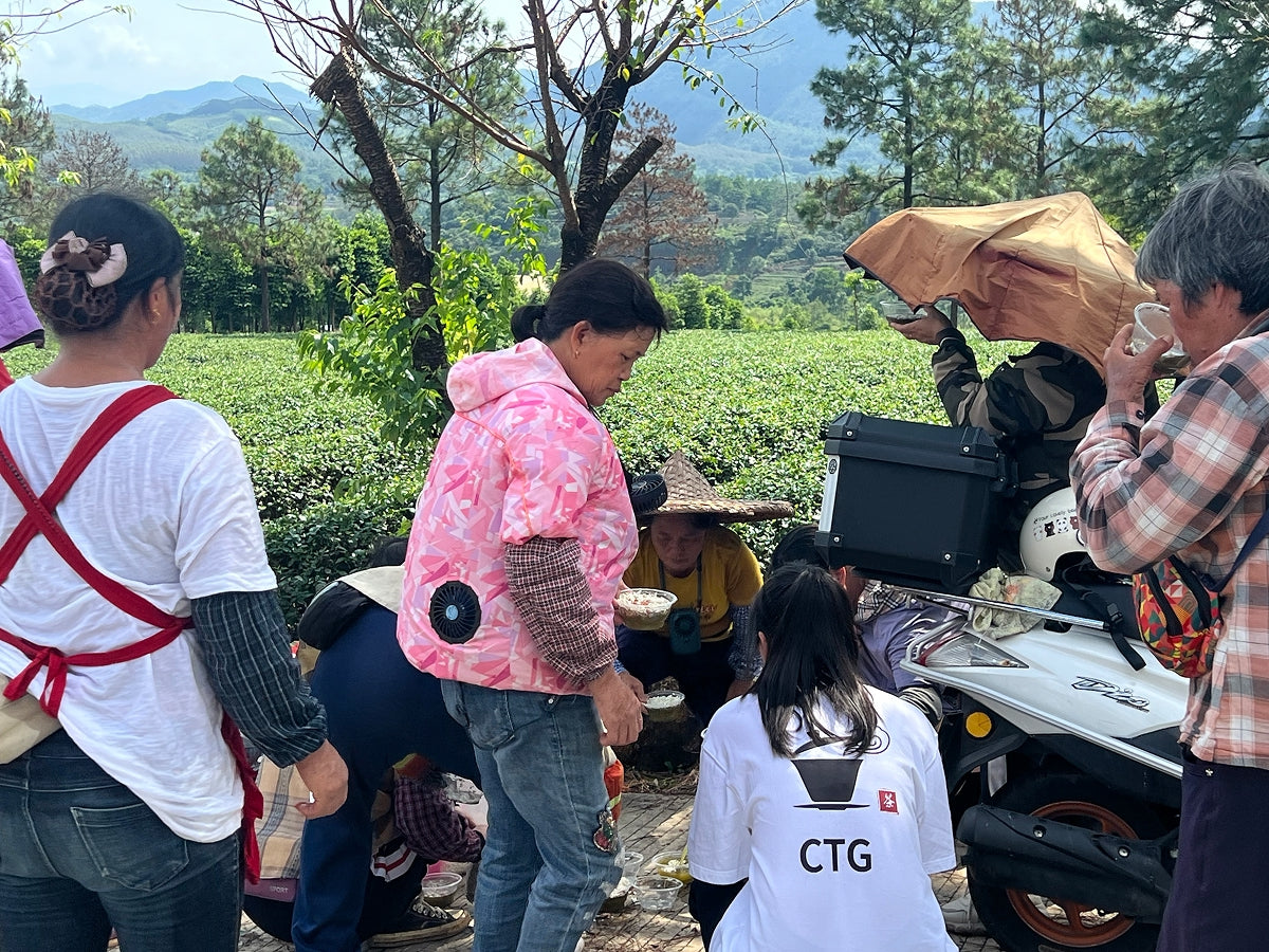 Tea master from Chinese Tea Group enjoying tea with farmers in the tea garden