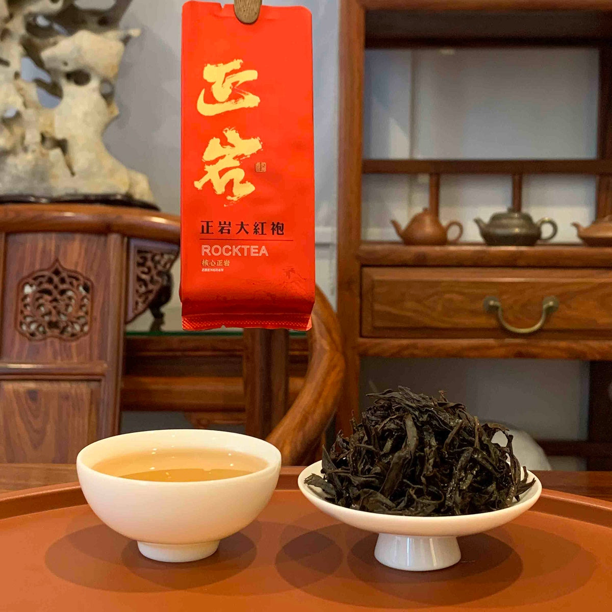 An individual tea bag and brewed tea liquor of Da Hong Pao Oolong Gongfu Tea Sachets