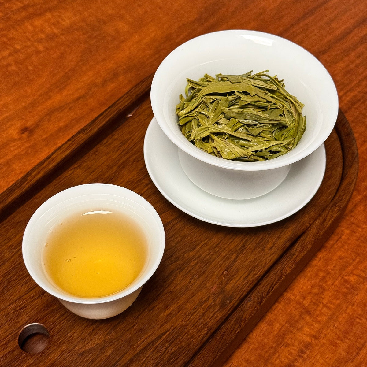 Long Jing Green Tea (Dragon Well) brewed tea liquor showing bright green color and clarity
