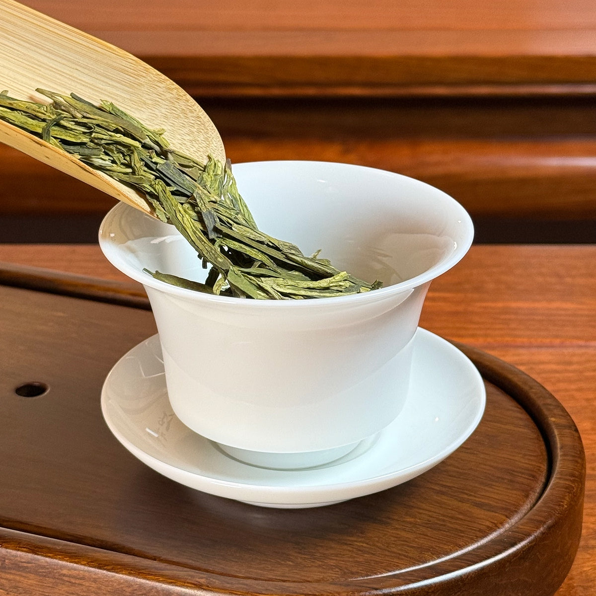 Long Jing Green Tea (Dragon Well) dry leaves poured into cup for authentic brewing