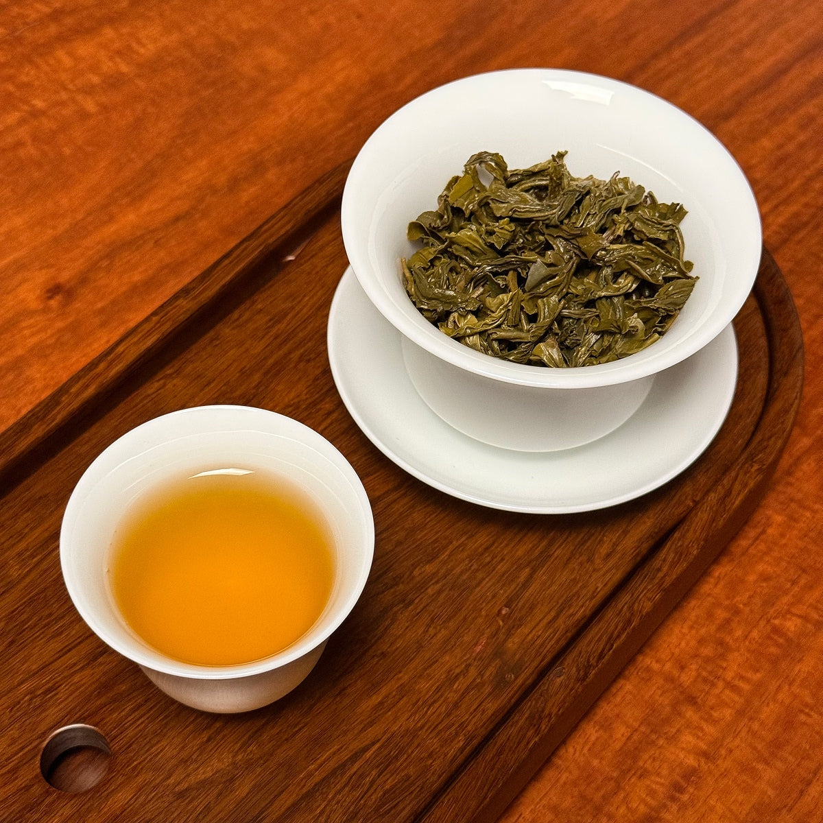 Rich Loose Leaf Green Tea Spring Harvest being observed by green tea enthusiasts, showing tea liquor and leaves