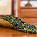 Tie Guan Yin Tea (Ti Kuan Yin / Iron Goddess) dry leaves close-up in Chinese Tea Group store