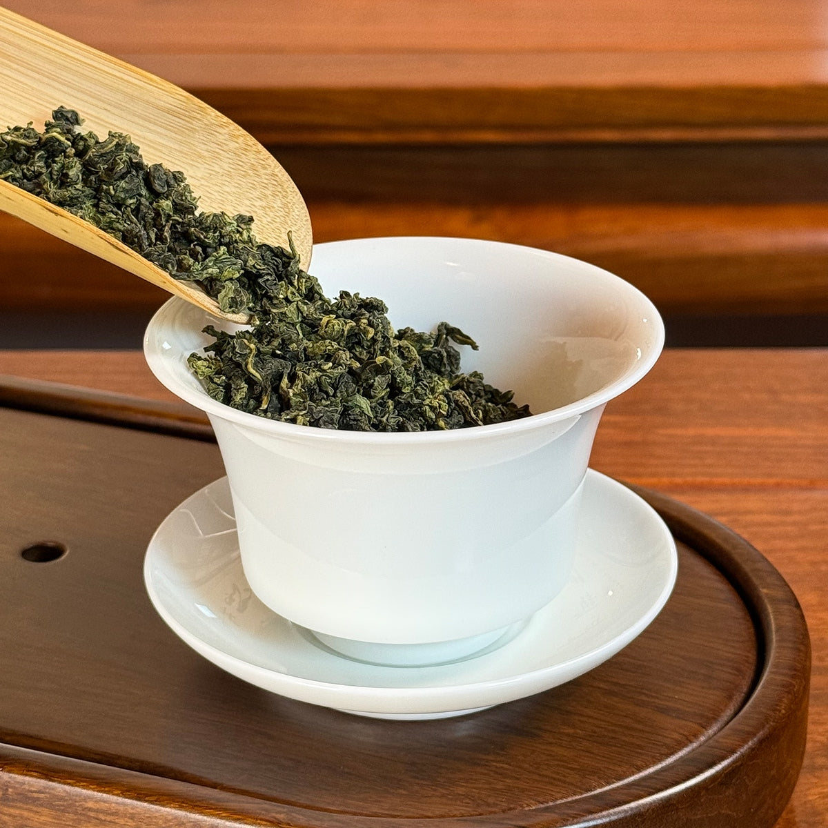 Tie Guan Yin Tea (Ti Kuan Yin / Iron Goddess) premium leaves poured into gaiwan for brewing