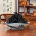 Close-up of Ya Shi Xiang Dan Cong dry leaves, tight dark rosette shape, premium oolong